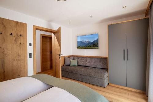 a bedroom with a bed and a couch at Apart Oberau - new from 2026 in Hippach