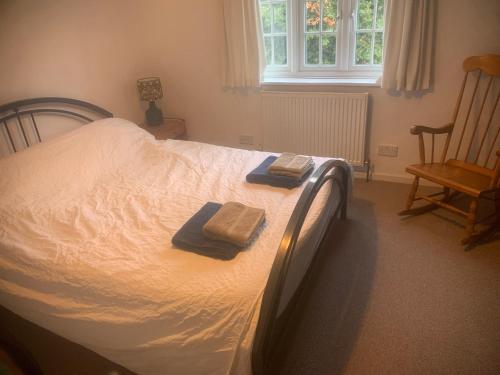 a bedroom with a bed with two towels on it at Spacious Suffolk Cottage in Village Setting in Westleton