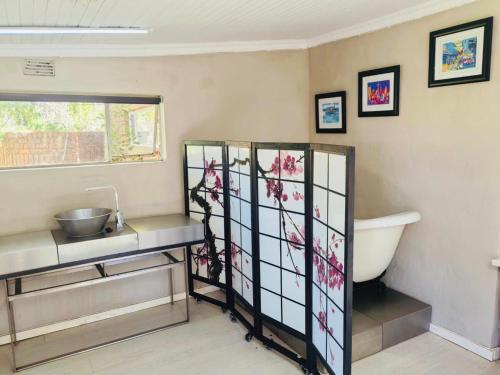 a bathroom with a sink and a bath tub at Kameeldoring Guesthouse in Zeerust