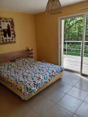 a bedroom with a bed and a large window at L'Airial du moulin in Parentis-en-Born