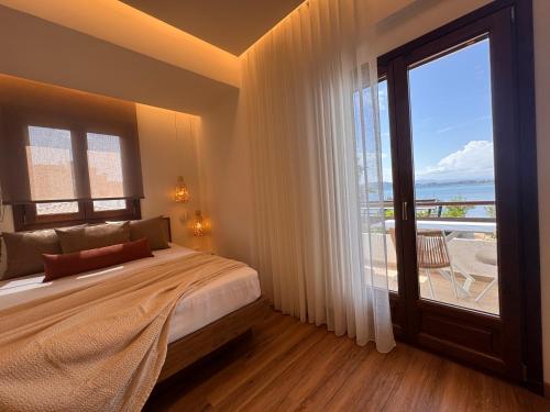 a bedroom with a bed and a large window at Christaras Apartments in Vourvourou