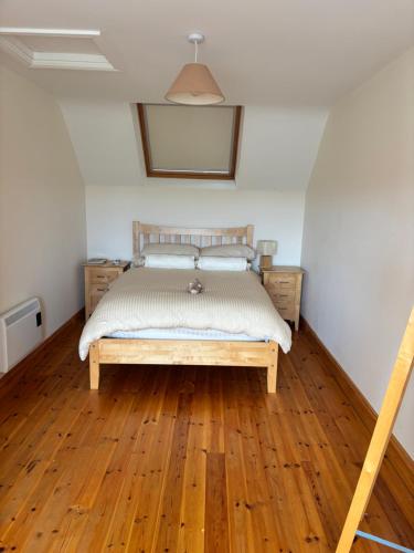 a bedroom with a bed and a wooden floor at Golf central in Rosslare Harbour