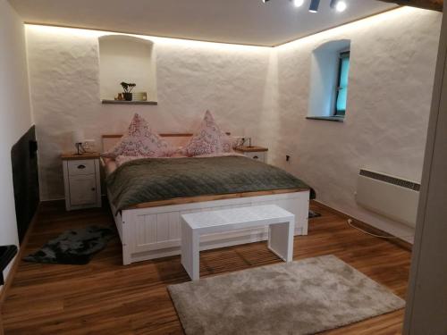 a bedroom with a bed with pink pillows on it at Landidyll Am Eisenberg in Kirchberg