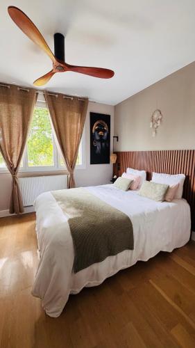 a bedroom with a large bed with a ceiling fan at Domaine S&B in Aubenas
