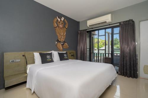 a bedroom with a large bed with a statue of a wrestler on the wall at Dent Station Residence in Ban Suan