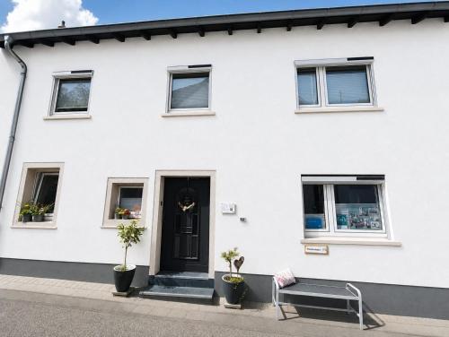 a white house with a bench in front of it at Ferienhaus Quell in Sankt Martin