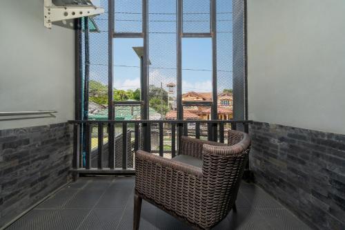 a wicker chair sitting on a balcony with a view at Dent Station Residence in Ban Suan