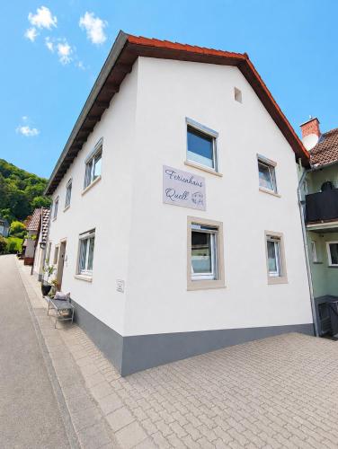 a white building with a sign on the side of it at Ferienhaus Quell in Sankt Martin