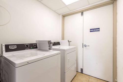 a white laundry room with a washer and dryer at Motel 6 New Brunswick in New Brunswick
