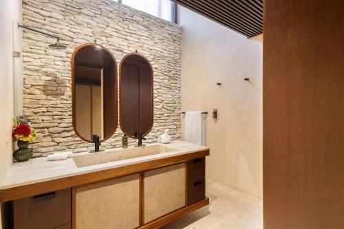 a bathroom with a sink and a stone wall at Beachfront Villa Soliman Bay- 8 bedrooms in Balcheil