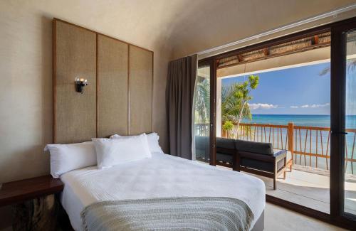 a bedroom with a bed and a balcony with the ocean at Beachfront Villa Soliman Bay- 8 bedrooms in Balcheil