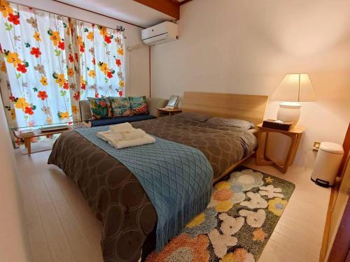 a hotel room with a bed and a window at Green Hights Residence-101 in Naha