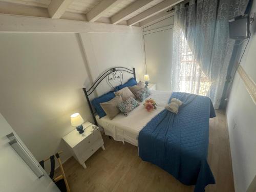 a bedroom with a blue bed and a window at La Terrazza Solarium, in pieno centro 60m dalla stazione ferroviaria 700m dal mare in Santa Flavia