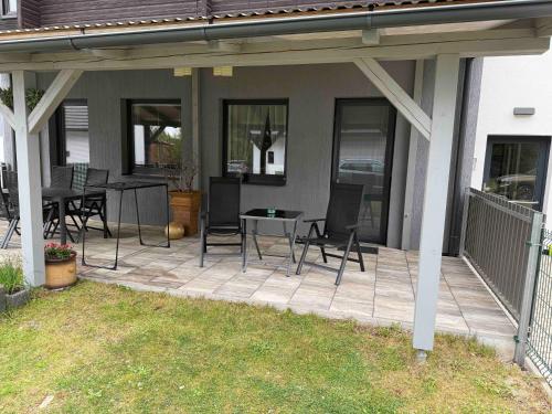 a patio with chairs and a table on a house at Náš Sen - Apartmán in Svratouch