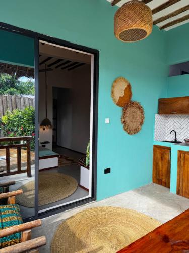 a mirror in a room with a blue wall at FURAHA GARDEN Rooms in Kendwa
