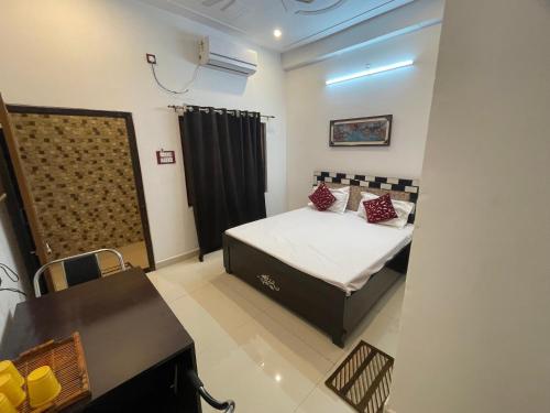 a bedroom with a bed and a table and a chair at Govind atithi greh in Ayodhya