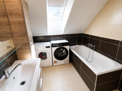 a bathroom with a washing machine and a sink at Apartmán Urban Kubín in Dolný Kubín