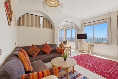a living room with a couch and a table at Surf Appart Morocco in Tamraght Ouzdar