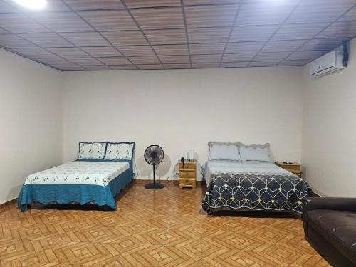 a living room with two beds and a couch at Tocumen Comfort Stay in Aserrío