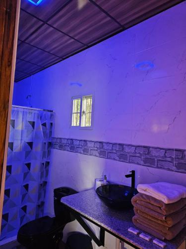 a bathroom with a sink in a purple room at Tocumen Comfort Stay in Aserrío