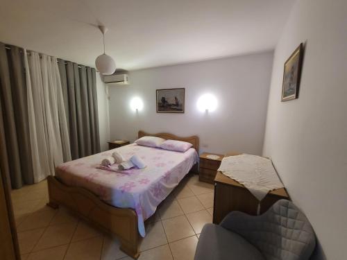a small bedroom with a bed and a chair at Geri Apartment in Ksamil