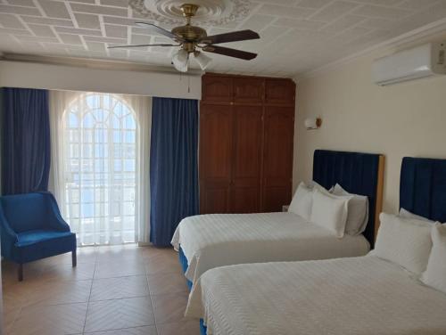 a hotel room with two beds and a ceiling fan at Hotel Casa Victoria in Tequila