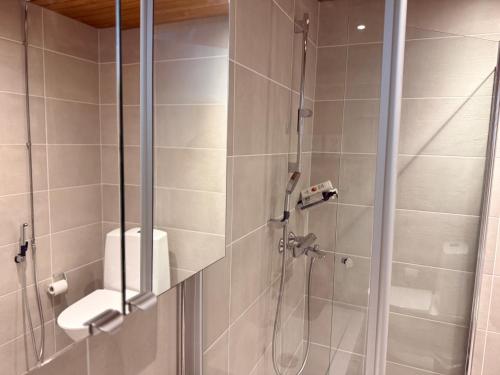 a bathroom with a shower with a glass door at The Seabreeze Terrace Apartment in Turku