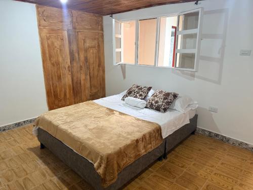 a bedroom with a bed and a window at Hostal Castillo in Filandia