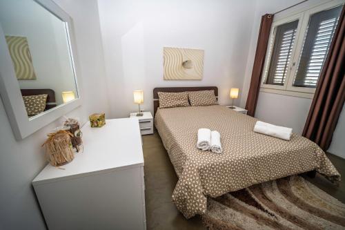 a small bedroom with a bed and a mirror at Villa Elen in Marsala