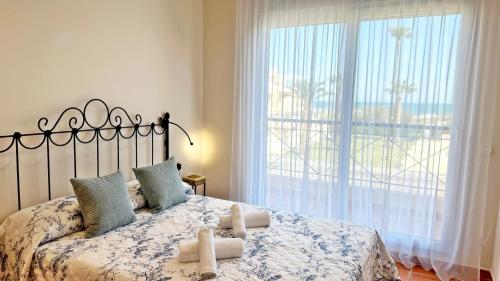 a bedroom with a bed with a large window at CASAS DEL MAR - Oliva Nova - Primera línea de Playa in Oliva