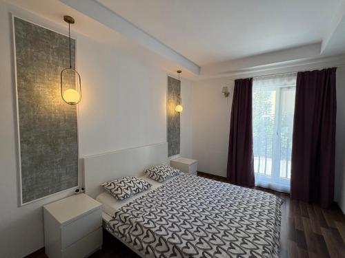 a bedroom with a bed and two pillows on it at Green Deluxe Apartment Cosmopolis in Ştefăneştii de Jos