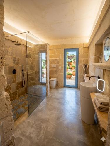 a bathroom with a glass shower and a sink at Masseria Petra in Martano