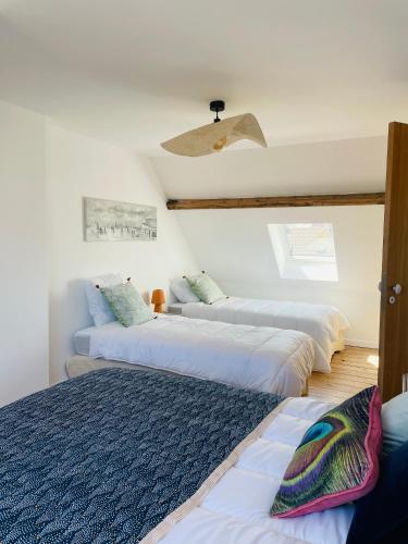 three beds in a room with a ceiling at Villa Le Cygne in Wimereux
