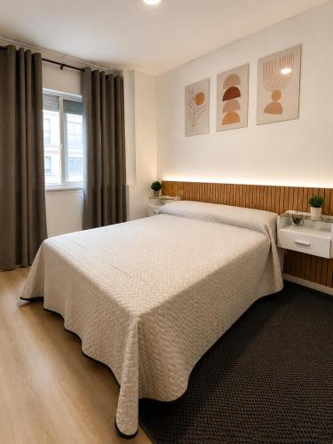 a bedroom with a large bed and a window at Casa Vilela in Arzúa