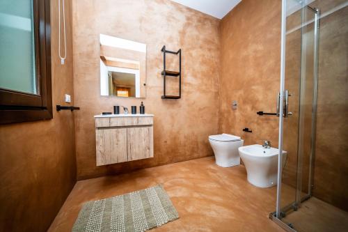 a bathroom with a toilet and a sink and a shower at Villa Elen in Marsala