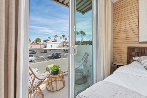 a bedroom with a bed and a balcony with a view at SW Beach Hotel in Hermosa Beach