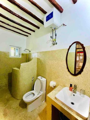 a bathroom with a toilet and a sink at Kome-Salsa Garden Comfortable big apartment in Jambiani