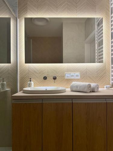 a bathroom with a sink and a large mirror at Moon&Mori in Augustów