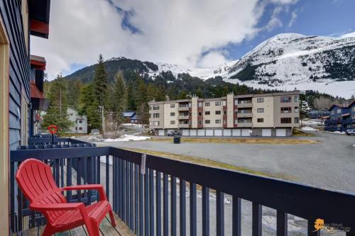 a red chair sitting on the balcony of a hotel at Alyeska Slope-Side Sanctuary in Girdwood