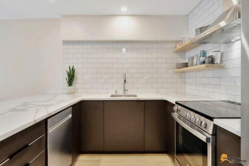 a white kitchen with a sink and a stove at Alyeska Slope-Side Sanctuary in Girdwood