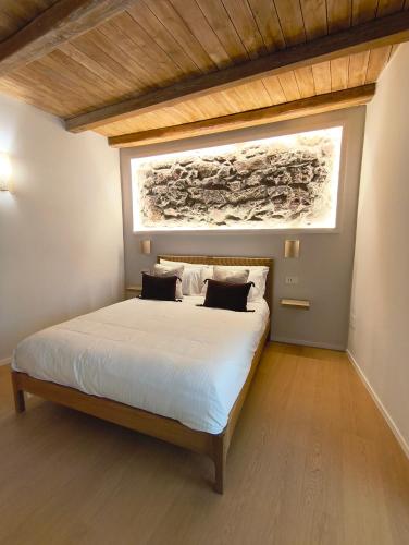 a bedroom with a bed with a painting on the wall at Insula Domo in Nuoro