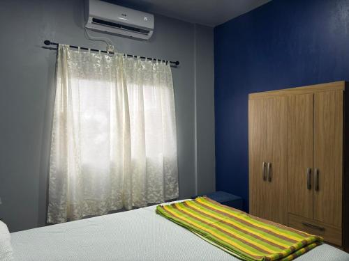 a bedroom with a bed and a window with a curtain at Escobar Sunset in Paraguarí
