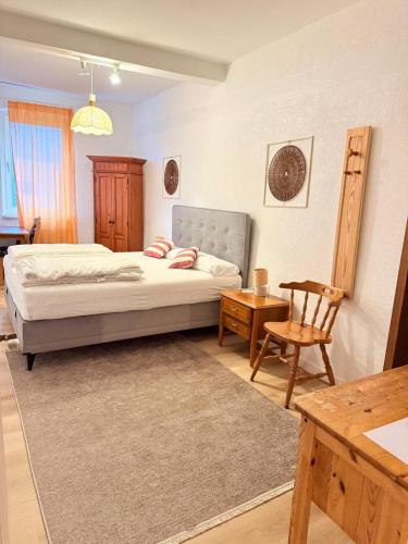 a bedroom with a bed and a chair and a table at Hotel Dreischläger Hof in Fernthal