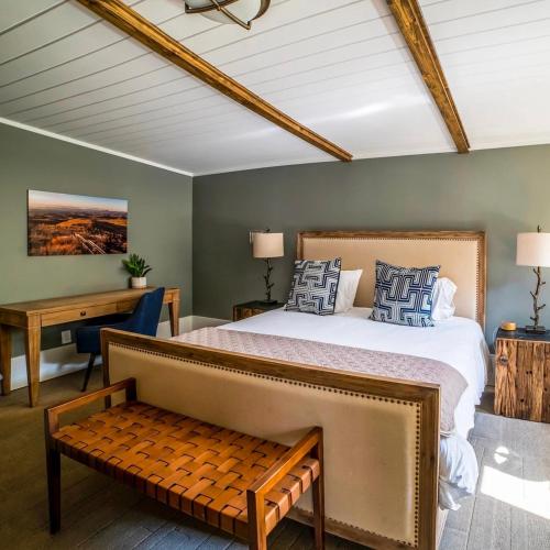 a bedroom with a large bed and a desk at Hellbender Bed & Beverage in Blowing Rock