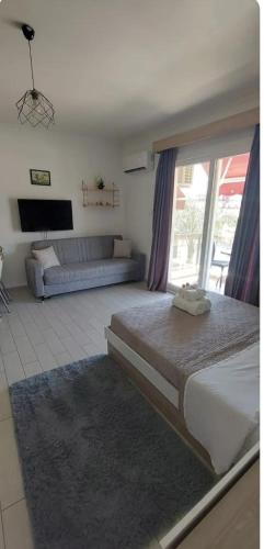a bedroom with a large bed and a couch at Kıbrısın gözdesi Long Beach de Havuz manzaralı stüdyo daire in Trikomo