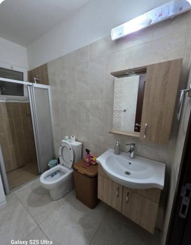 a bathroom with a sink and a toilet at Kıbrısın gözdesi Long Beach de Havuz manzaralı stüdyo daire in Trikomo