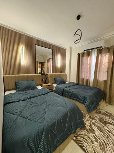 a bedroom with two beds and a mirror at Luxury Stay in Cairo in Sheikh Zayed