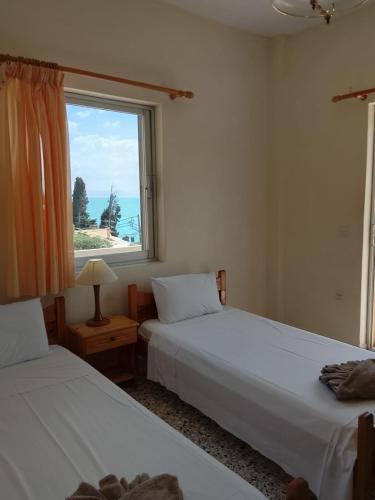 two beds sitting in a room with a window at EMILIOS SEE VIEW in Barbati