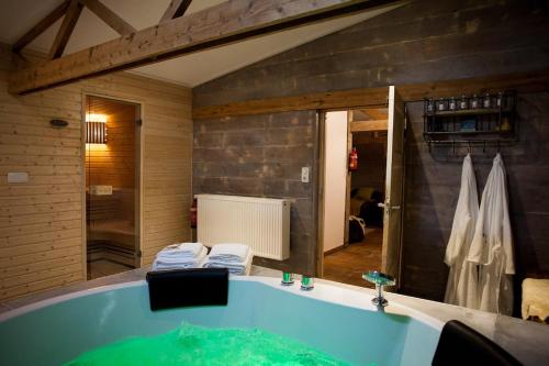 a bathroom with a large tub with a shower at Hut 16 Bed, stad & privé wellness in Zutphen