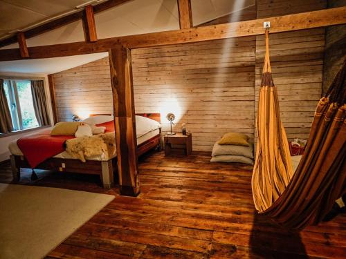a bedroom with a bed and a hammock in a room at Hut 16 Bed, stad & privé wellness in Zutphen